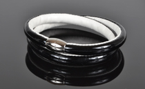 Armbånd i sort lak læder og hvid kalveskind. 2 omgange med magnetlås i stål. Tykkelse 7,5 mm.